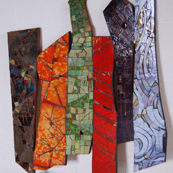 Six tall, abstract mosaic panels with varied colors and textures lean against a white wall.