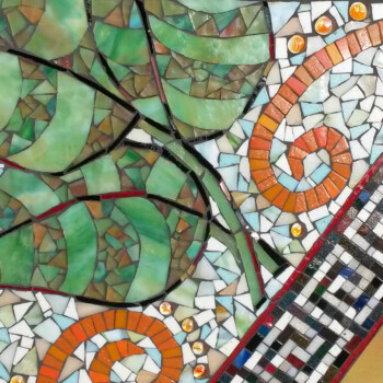 Colorful mosaic featuring green leaves, orange spirals, and a patterned border with black, white, and red tiles.