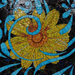 Mosaic artwork depicting a yellow flower with blue swirl patterns on a dark background.