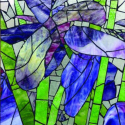 Stained glass artwork featuring abstract blue and purple flowers with green stems and leaves.