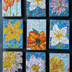 Nine colorful mosaic tiles featuring various stylized flowers arranged in a grid pattern against a dark background.