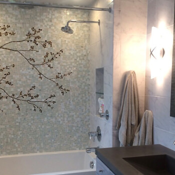 SOLD Bathroom with a bathtub, mosaic tile wall featuring a tree branch design, towels hanging, and a modern vanity.