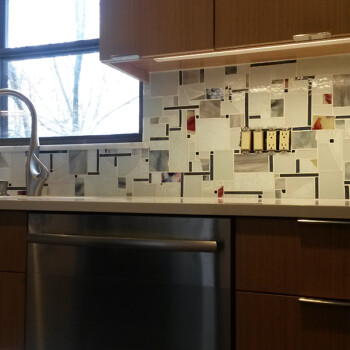 SOLD Modern kitchen with a stainless steel dishwasher, mosaic tile backsplash, wood cabinets, and a window above the sink.