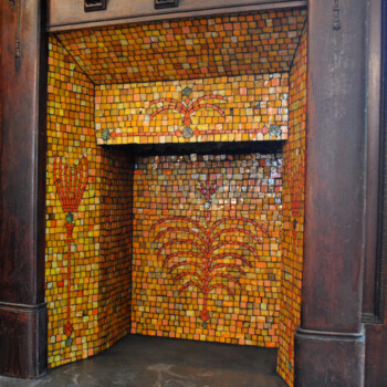 SOLD Fireplace with a wooden mantel and yellow mosaic tile interior featuring red and green decorative patterns.