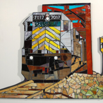 Mosaic artwork of a train engine numbered 7017 with geometric shapes, a track, and a yellow railroad sign reading 710.