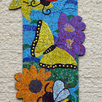 SOLD Colorful mosaic mural depicting a ladybug, butterfly, bee, sunflowers, and purple flowers on a brick wall.