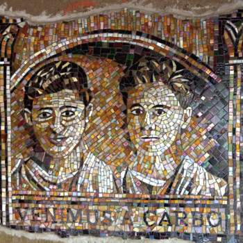 Mosaic artwork depicting two people with the words "VENIMUS A SACRO" beneath them in capital letters.